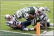  ?? BILL KOSTROUN — THE ASSOCIATED PRESS ?? Jets’ Austin Seferian-Jenkins is tackled by Patriots’ Malcolm Butler, left, and Duron Harmon. After further review the play was ruled a fumble into the end zone.