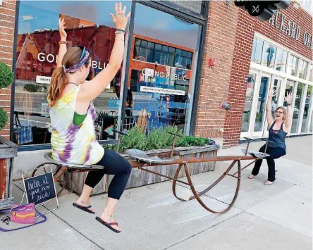  ?? ARCHIVES] [PHOTO BY NATE BILLINGS, THE OKLAHOMAN ?? Amy Shrodes, left, and Amy Donaldson ride a teeter totter in 2016 outside of Plenty Mercantile in Automobile Alley.