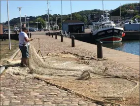  ?? JANET PODOLAK — THE NEWS-HERALD ?? A fisherman mends his net near the harbor at Honfleur.