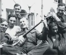  ??  ?? Len entertaini­ng his comrades with his banjo during the war years.