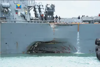  ?? U.S. Navy ?? Damage to the port side is visible on the John S. McCain as the destroyer steers toward a naval base in Singapore after a collision with a merchant vessel. Ten sailors are missing.