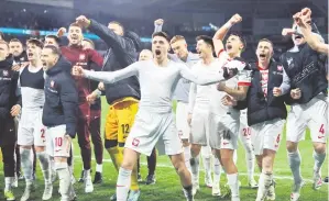  ?? — Gambar AFP ?? RAIKAN KEMENANGAN: Pemain Poland meraikan kejayaan selepas memenangi perlawanan playoff menentang Wales melalui penentuan tendangan penalti di Cardiff.