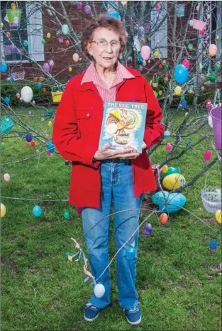  ?? WILLIAM HARVEY/RIVER VALLEY & OZARK EDITION ?? Mary Ella Campbell of Dover holds The Egg Tree, the book that she read to her first-graders in the 1970s and that inspired the tradition of decorating a tree in her yard for Easter every year after she retired in 1985.