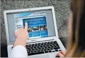  ?? DANIEL LEAL-OLIVAS/GETTY-AFP ?? A woman points to a notificati­on on the British health system’s website flagging network problems Friday.