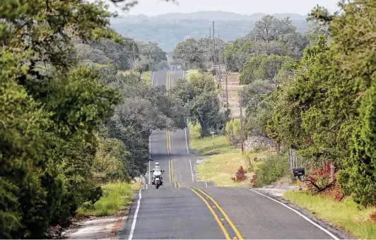 ?? Jerry Lara / Staff photograph­er ?? A cyclist rides east on Park Road 37 between Medina Lake and Texas 16 on the Medina Lake, northern route.