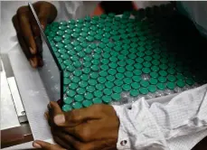  ??  ?? MUCH AWAITED: An employee handles vials of AstraZenec­a’s Covishield vaccine at the Serum Institute of India in Pune on Monday (30)