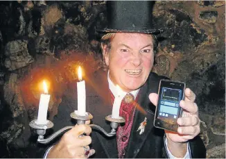  ??  ?? TAPPING IN: Mystery Ghost Bus tour host Mark Rose-Christie shows the cellphone version of the Spirit Box for the tour