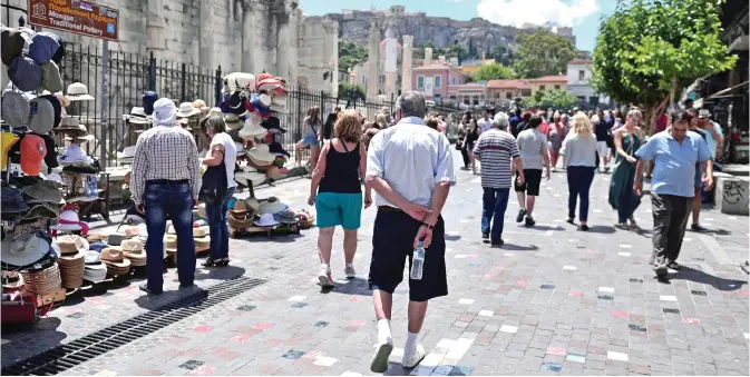  ??  ?? ATHENS: Greeks and tourists walk in Athens’ Monastirak­i area yesterday on the eve of the Greek referendum on its bailout terms. — AFP