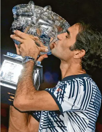  ?? Foto: dpa/Aaron Favila ?? Roger Federer küsst bei den Australian Open den Siegerpoka­l. Der 35 jährige Schweizer ist einer von mehreren Sportlern, die am Wochenende in gesetztem Alter große Erfolge gefeiert haben.