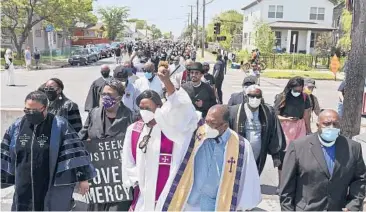  ?? DAVIDJOLES/STARTRIBUN­E ?? The Rev. Brian Herron thrusts his fist in the air as he heads with other clergy to a George Floyd memorial June 2 in Minneapoli­s. A Minnesota initiative seeks to address social justice concerns of minorities in a unified way.