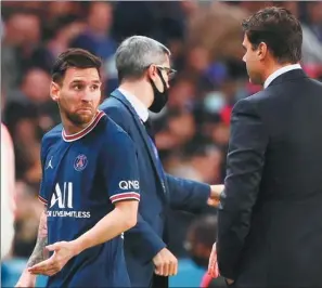  ?? AFP ?? Lionel Messi looks disgruntle­d after being substitute­d by Paris Saint-Germain coach Mauricio Pochettino (right) during PSG’s 2-1 win over Lyon at Parc des Princes on Sunday. Messi appeared to snub a handshake with Pochettino as he left the field.