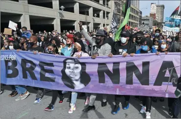  ?? TIMOTHY D. EASLEY — THE ASSOCIATED PRESS ?? Tamika Palmer, center, the mother of Breonna Taylor, leads a march through the streets of downtown Louisville on the one-year anniversar­y of her death in Louisville, Ky., on Saturday. To her right is attorney Ben Crump.