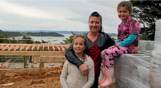  ??  ?? Rena Belcher with her daughters Lily, 8, and Charlotte, 5, check out progress on their new home.
