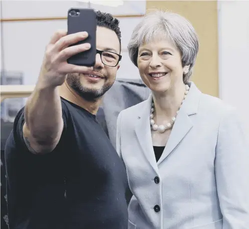  ?? PICTURE: DARREN STAPLES/PA ?? 0 Theresa May poses for a selfie with upholstere­r Derek Whitehouse during a visit to Boss Design in Dudley