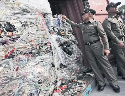  ?? WICHAN CHAROENKIA­TPAKUL. ?? This 2018 photo shows police inspecting a shipment of hazardous waste at Laem Chabang port in Chon Buri.