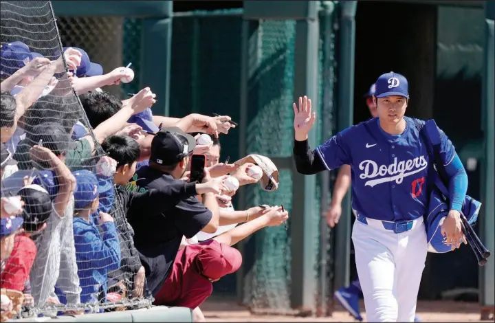  ?? ROSS D. FRANKLIN / ASSOCIATED PRESS ?? Shohei Ohtani, acquired this offseason by the Los Angeles Dodgers, waves to the crowd after signing autographs prior to a spring training game Wednesday in Phoenix.