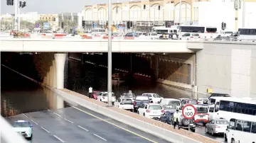  ??  ?? Motorists drive through a flooded tunnel in the Qatari capital Doha, following heavy rainfall. — AFP photo