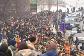  ?? ASSOCIATED PRESS ?? Police, right, observe as people walk toward the Borisovsko­ye Cemetery for the funeral ceremony of Russian opposition leader Alexei Navalny in Moscow, Russia.