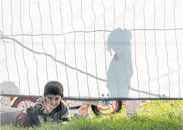  ?? AP ?? Children play near a fence around an asylum seekers shelter in Heidenau, near Dresden, eastern Germany.