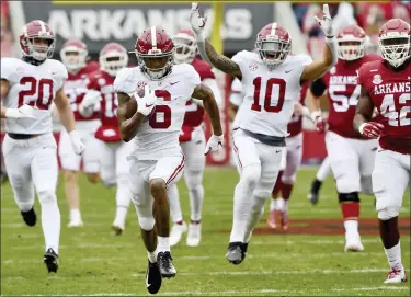  ?? MICHAEL WOODS — THE ASSOCIATED PRESS ?? Alabama punt returner Devonta Smith, middle, returns a punt for a touchdown against Arkansas during Saturday’s win.
