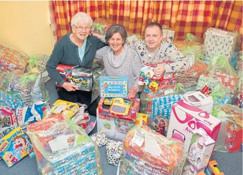  ??  ?? FESTIVE CHEER: Irene Gillies, Kathleen Strachan and Paul Cassidy with donated gifts.