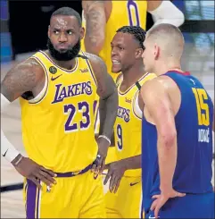  ?? AP ?? Los Angeles Lakers' Lebron James (23) and Rajon Rondo (9) and Denver Nuggets' Nikola Jokic wait for play to restart during the second half of Game 1 of the Western Conference finals Friday night in Lake Buena Vista, Fla.