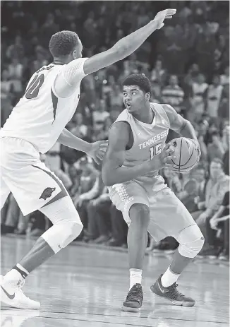  ?? THE ASSOCIATED PRESS ?? Tennessee freshman forward Derrick Walker is guarded by Daniel Gafford during the Vols’ game against Arkansas in Fayettevil­le last month.