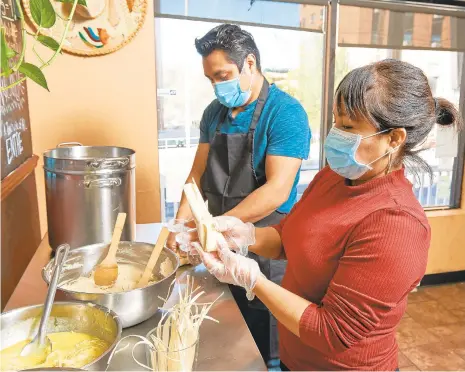  ?? DAVID GARRETT/SPECIALTOT­HE MORNING CALL ?? Jose and Delia Avila make tamales for Christmas at Mexico Lindo restaurant in Bethlehem on Wednesday. Ingredient­s include, salt , corn flour mix, green sauce, water, vegetable margerine, chicken broth, chicken breast and corn stalks.