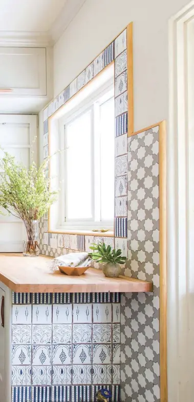  ??  ?? "I love thatthe tile pattern felt like it could have been original to the home.” The tilework elevates the look of the simple wooden countertop, while wire baskets for storage provide a chic and easy way to clean up.