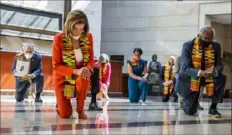  ?? Manuel Balce Ceneta/Associated Press ?? House Speaker Nancy Pelosi, D-Calif., second from left, and other members of Congress kneel and observe a moment of silence at the Capitol's Emancipati­on Hall on Monday.