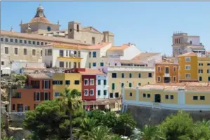  ?? ALBERT STUMM, THE ASSOCIATED PRESS ?? Colourful buildings in Mahon, the capital of Menorca. A British influence lingers in the city, a holdover from 18th century rule that greatly benefited the island. ALBERT STUMM