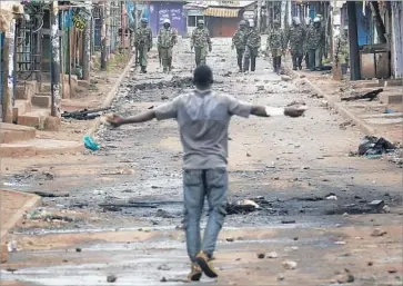  ?? Dai Kurokawa European Pressphoto Agency ?? A SUPPORTER of opposition leader Raila Odinga confronts officers in the Kibera slum in Nairobi, Kenya.