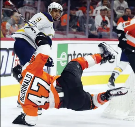  ?? CHRIS SZAGOLA — THE ASSOCIATED PRESS ?? The Flyers’ Andrew MacDonald, bottom, goes flying Thursday night. after a hit by Buffalo’s Evander Kane, top, during the third period on