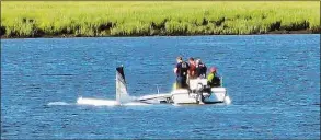  ?? Contribute­d photo ?? Emergency personnel are seen near a small plane that went into the Quinnipiac River Thursday in New Haven.