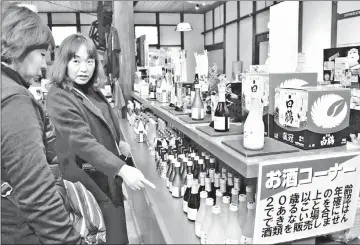  ??  ?? Visitors buy sake at the Hakutsuru Sake Brewery Museum in Kobe. — Japan News-Yomiuri photo