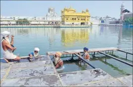  ??  ?? ■ Volunteers putting up an iron structure on the banks of the sarovar at the Golden Temple in Amritsar on Thursday. SAMEER SEHGAL/HT