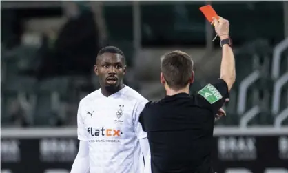  ?? Photograph: Marius Becker/ AP ?? Referee Frank Willenborg shows Marcus Thuram the red card during Gladbach’s home defeat to Hoffenheim.