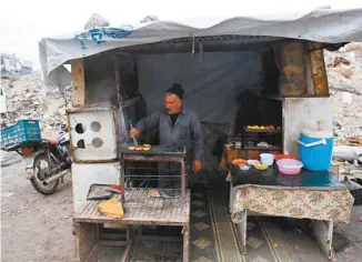  ?? GEORGE OURFALIAN AGENCE FRANCE-PRESSE ?? Un Syrien, Khayro Moselmani, vend de la nourriture dans Kalassé, un ancien quartier rebelle d’Alep.