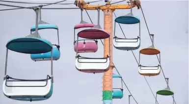  ??  ?? Empty sky gliders hang above the Santa Cruz (Calif.) Beach Boardwalk in July. Tourism accounted for 7% of global trade in 2019.