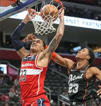  ?? Paul Sancya/Associated Press ?? Washington’s Kyle Kuzma, left, dunks for two of his 30 points Saturday as the Wizards defeated the Pistons in Detroit.