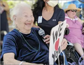  ??  ?? Hale Makua Kahului resident Peggy Pagan holds a sign to greet the parade Tuesday at the facility. Next to her and partially obscured is staff member Jodi Horton.