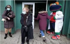  ?? NANcy lANE / hERAlD stAFF FilE ?? AT LEAST THERE’S WALLY: Lorraine O’Brien and Susan Johansen are greeted by Red Sox mascot ‘Wally’ outside the Fenway Park vaccinatio­n site on Feb. 1 after they were vaccinated. The Fenway cost of $540,013 includes $235,046 in expenses plus a $304,967 minimum weekly payment.