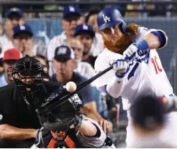  ?? (Reuters) ?? THE LOS ANGELES DODGERS’ Justin Turner hits a two-run homer against the Houston Astros in the sixth inning of Tuesday night’s Game 1 of the World Series for the decisive runs in the Dodgers’ 3-1 home victory.