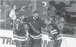  ?? FRANK FRANKLIN II/AP ?? The Rangers’ Alexis Lafreniere, middle, celebrates with teammates Filip Chytil, left, and Jacob Trouba after scoring a goal against the Penguins on Wednesday in New York.