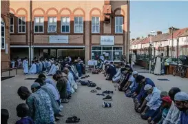  ?? Andrew Testa / New York Times ?? Worshipper­s pray in the parking lot of London’s Al Madina Mosque, where all the main prayer areas are full. In the working-class East London neighborho­od of Barking, roughly 9,000 people attended the morning prayer session.