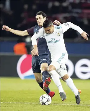 ??  ?? PSG’s Edinson Cavani (left) tries to stop Real Madrid’s Casemiro during the Round of 16, second-leg Champions League match between Paris Saint-Germain and Real Madrid at the Parc des Princes Stadium in Paris, yesterday. Real Madrid won 2-1.