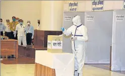  ?? PTI ?? An MLA, wearing PPE, casts his vote at the MP state assembly in Bhopal on Friday. n