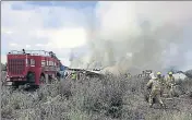  ?? AFP ?? Firemen work as smoke billows from the wreckage of the plane.