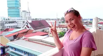  ??  ?? A member of the duo has her photo taken on top of a pagoda, where the panoramic view of Sibu can be seen.