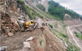  ?? PHOTO: REUTERS ?? A bulldozer clears a landslide from India’s Tezpur-Tawang highway, which runs to the Chinese border, in Arunachal Pradesh.